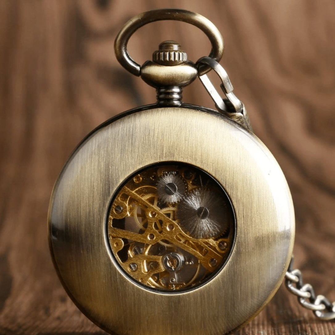Close-up of a bronze pocket watch with visible gears.
