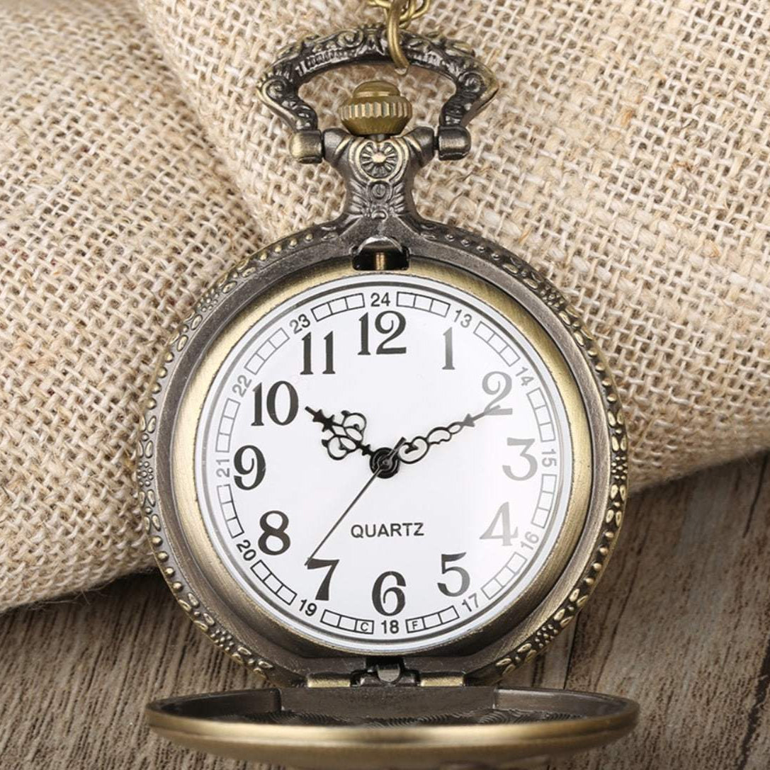 Close-up of vintage bronze pocket watch on wooden and burlap background.
