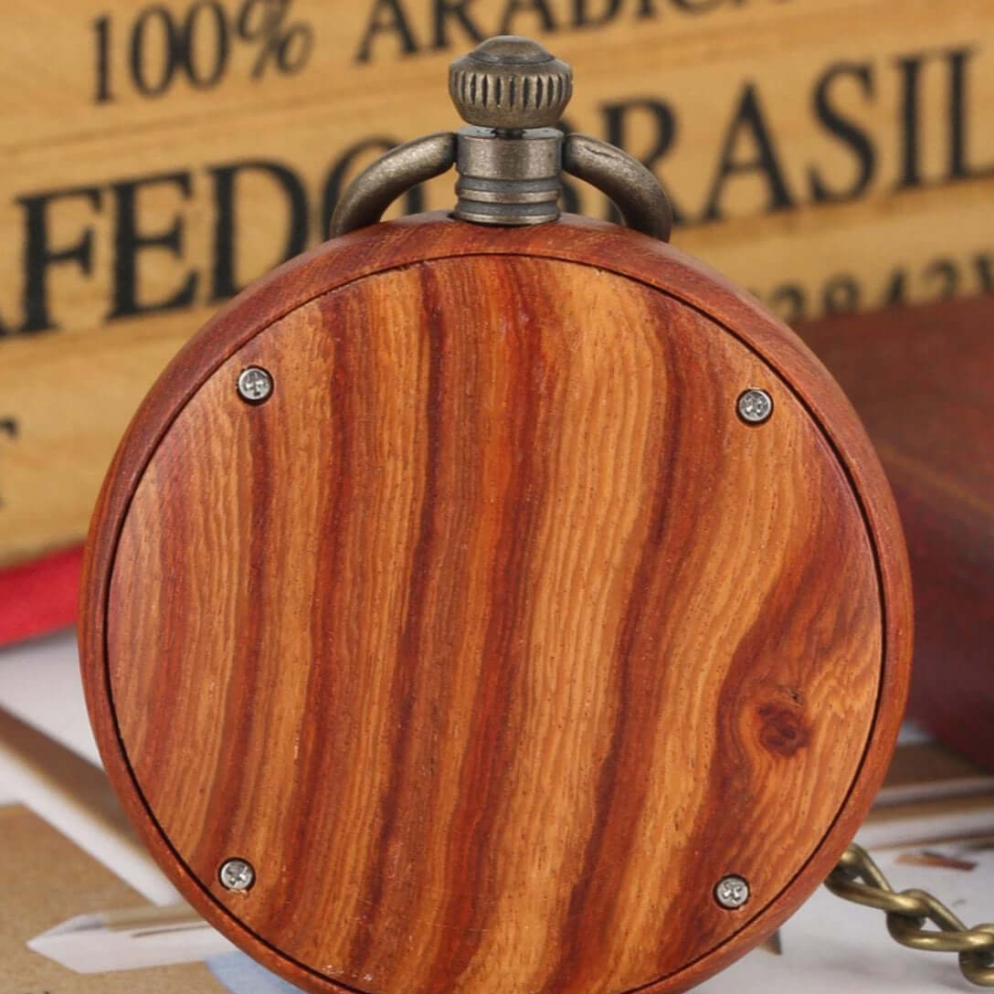 Close-up of a wooden pocket watch with a metal crown and chain.