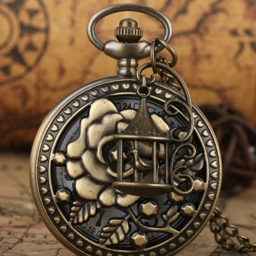Close-up of antique bronze pocket watch with floral design and birdcage detail.