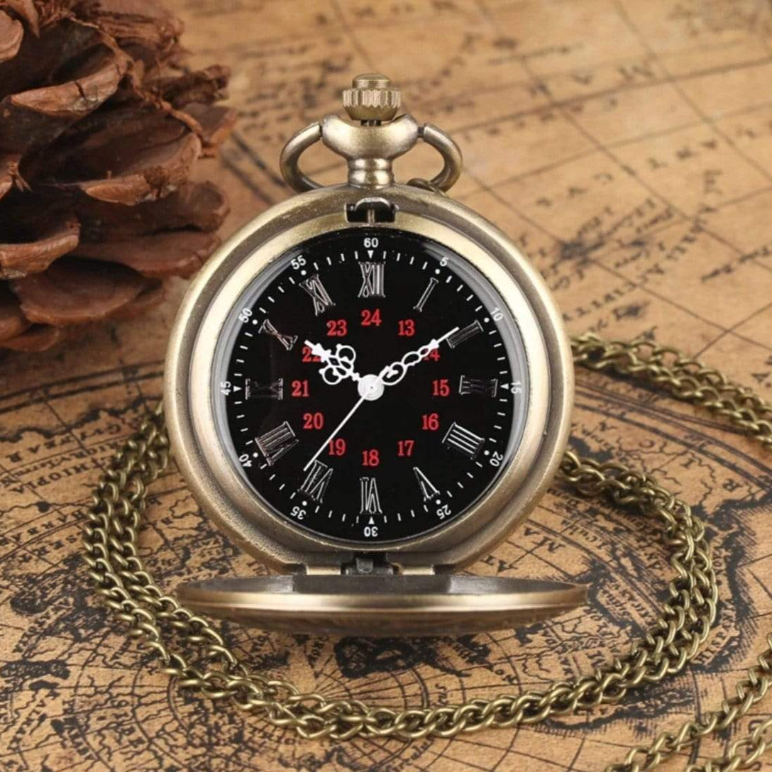 Bronze pocket watch with Roman and Arabic numerals, set against a backdrop of an antique map and a pine cone.