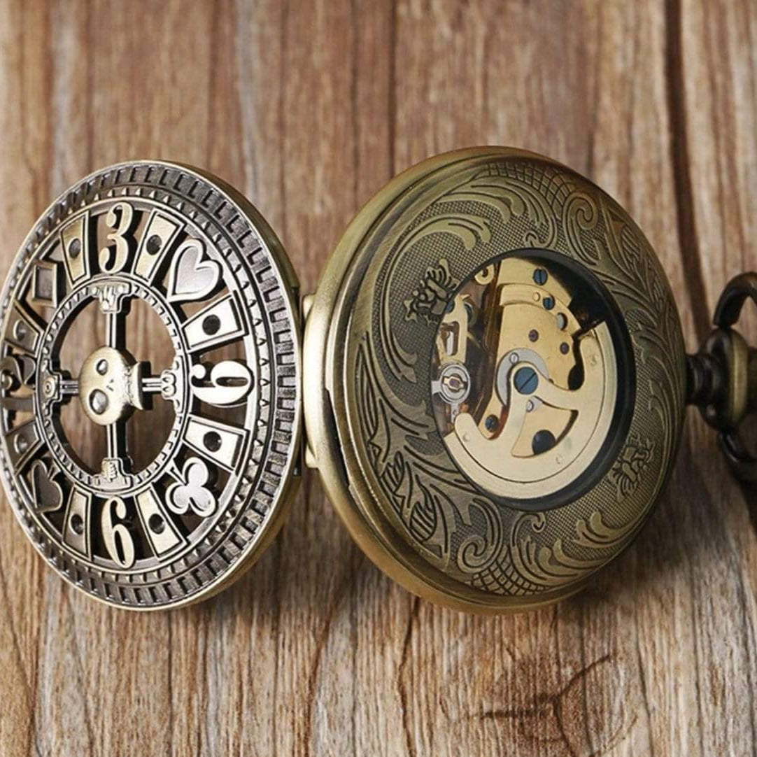 Open ornate bronze pocket watch with exposed gears.
