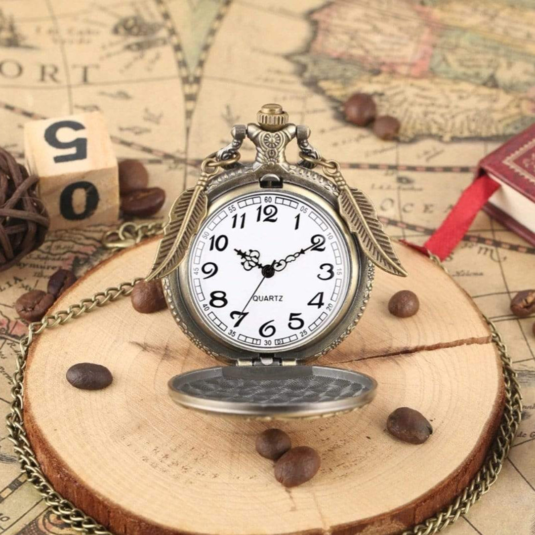 A vintage pocket watch with feathers, coffee beans, a wooden disk, and a map background.

