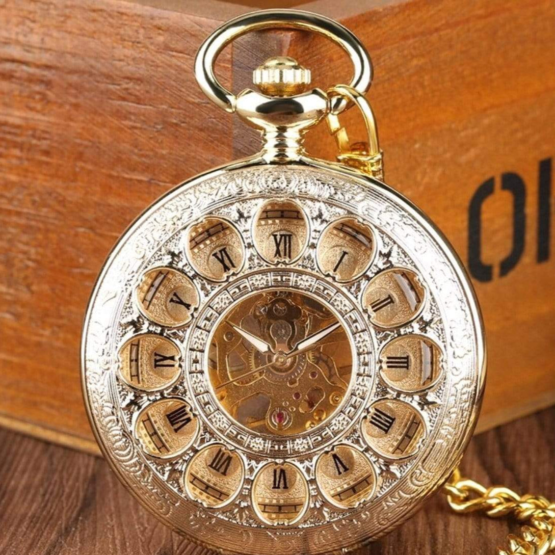 Gold pocket watch with Roman numerals, decorative border, and chain.

