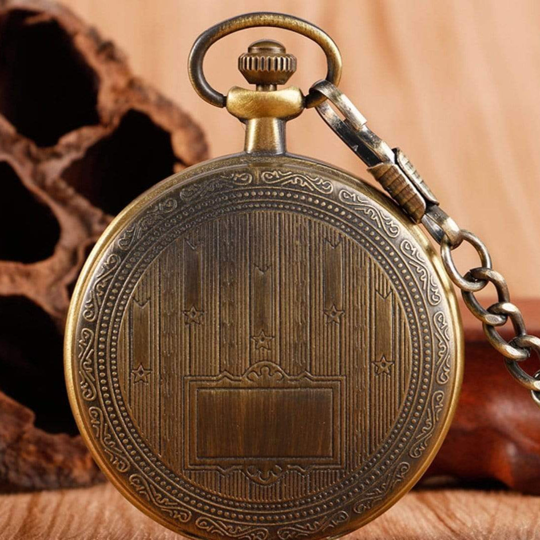 Close-up of an antique-style bronze pocket watch with a chain.