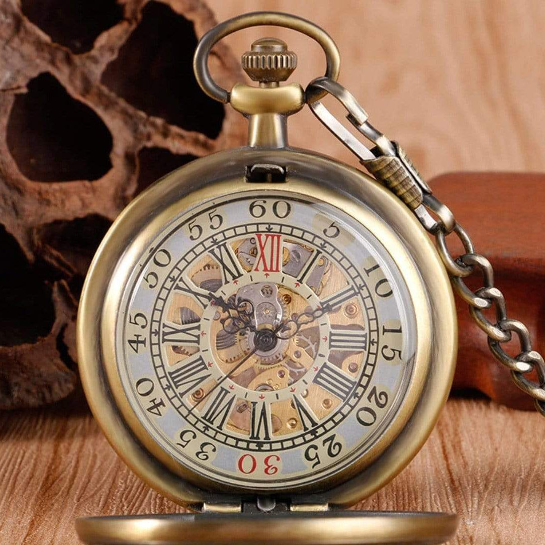 Close-up of an antique brass pocket watch with a visible gear mechanism and chain.