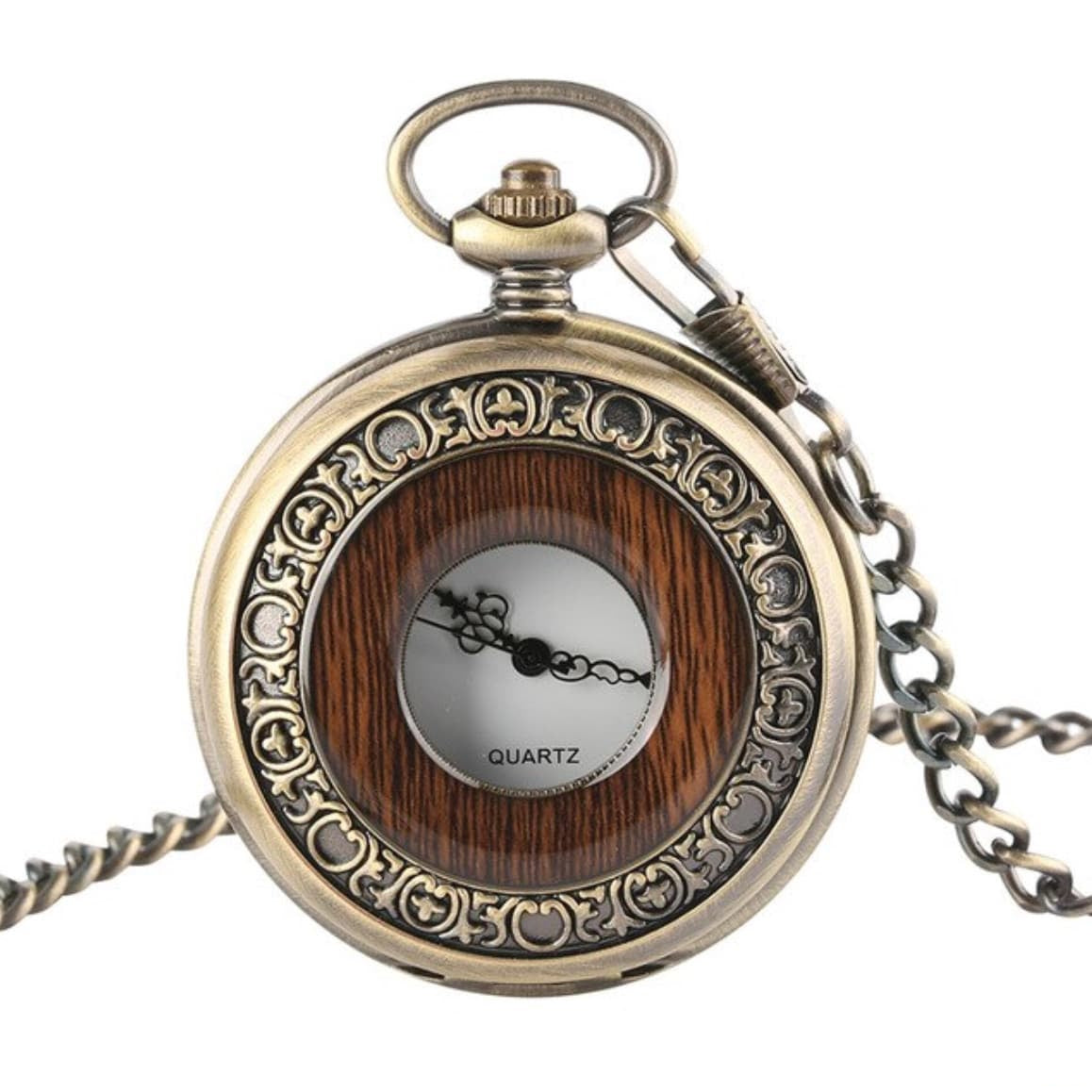 Close-up of an ornate, bronze-toned pocket watch with a wooden inlay and a white face displaying "QUARTZ". It hangs from a chain.