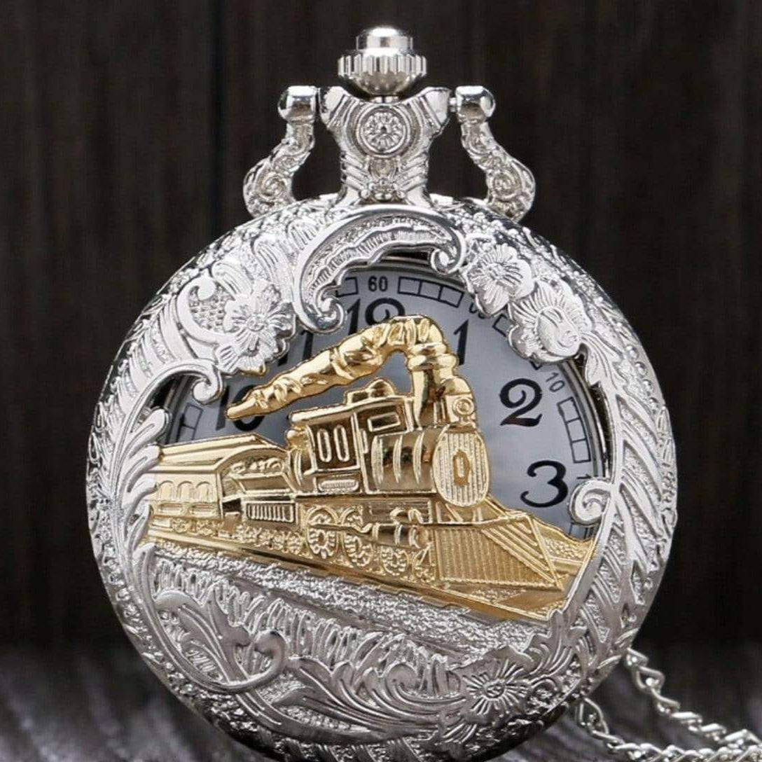 Silver and gold pocket watch with a train design on the face.