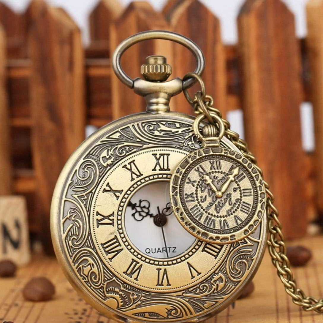 Close-up of an antique brass pocket watch with Roman numerals and a smaller decorative pocket watch.