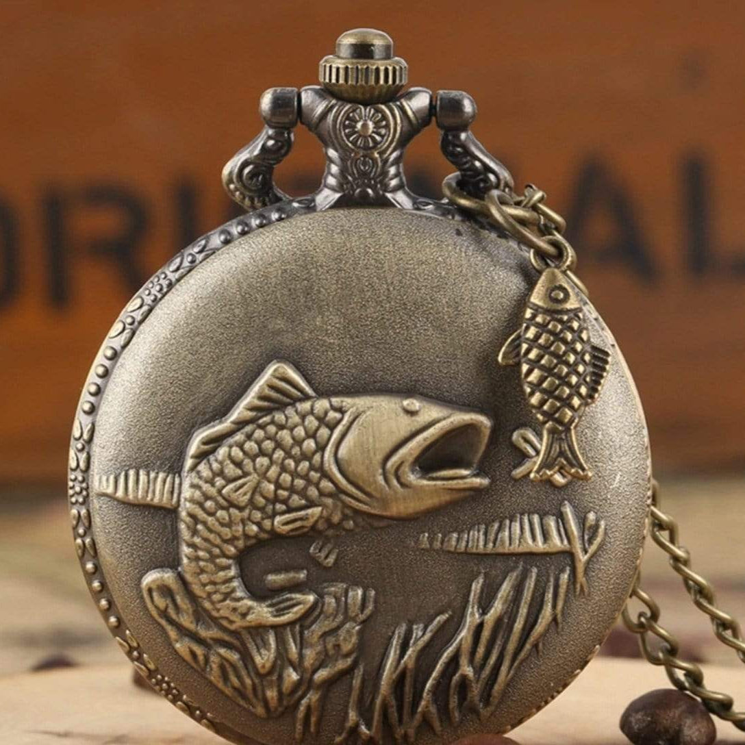 Antique gold pocket watch with fish design.
