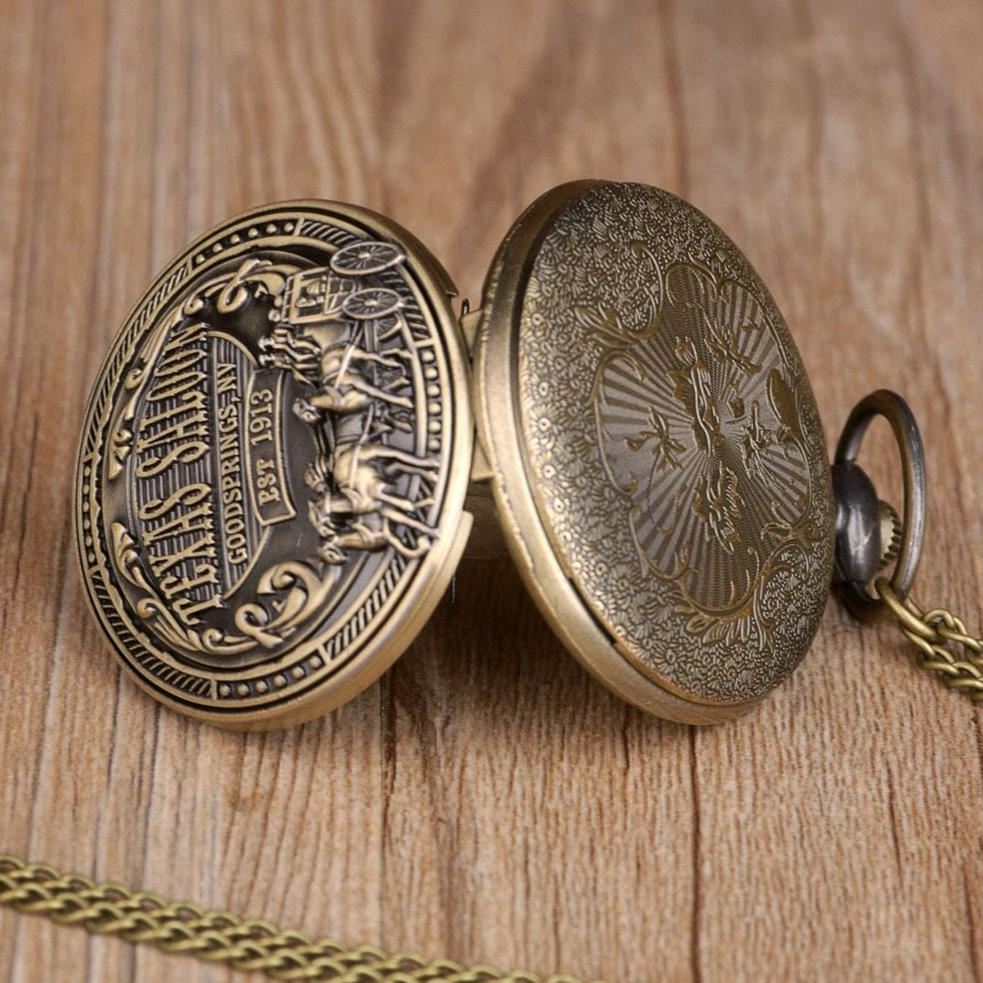 Open gold pocket watch with chain, resting on a wooden surface.
