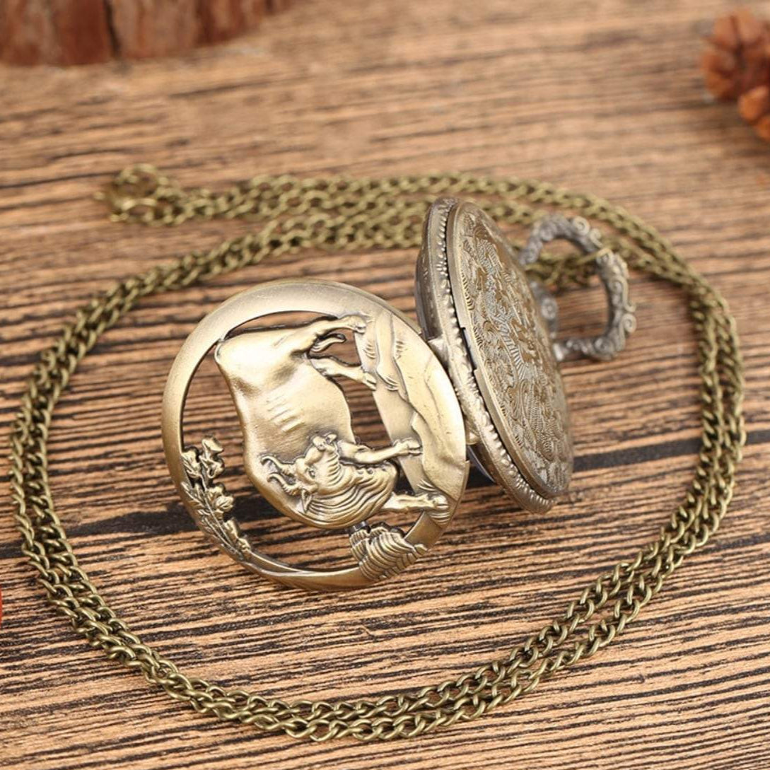 Antique bronze pocket watch with chain, showing a rider on horseback.