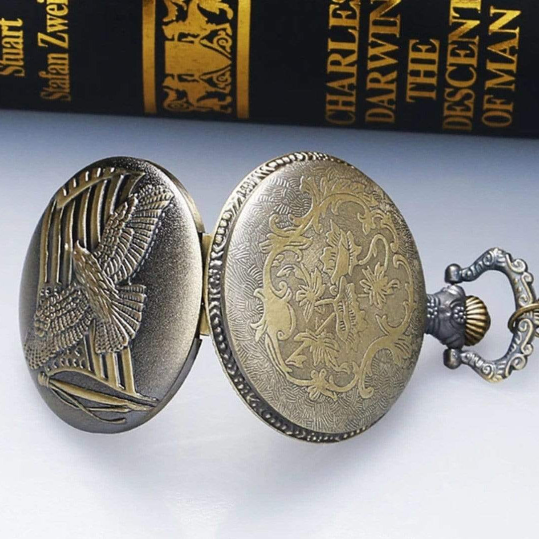 Open antique bronze pocket watch with an eagle on the lid.