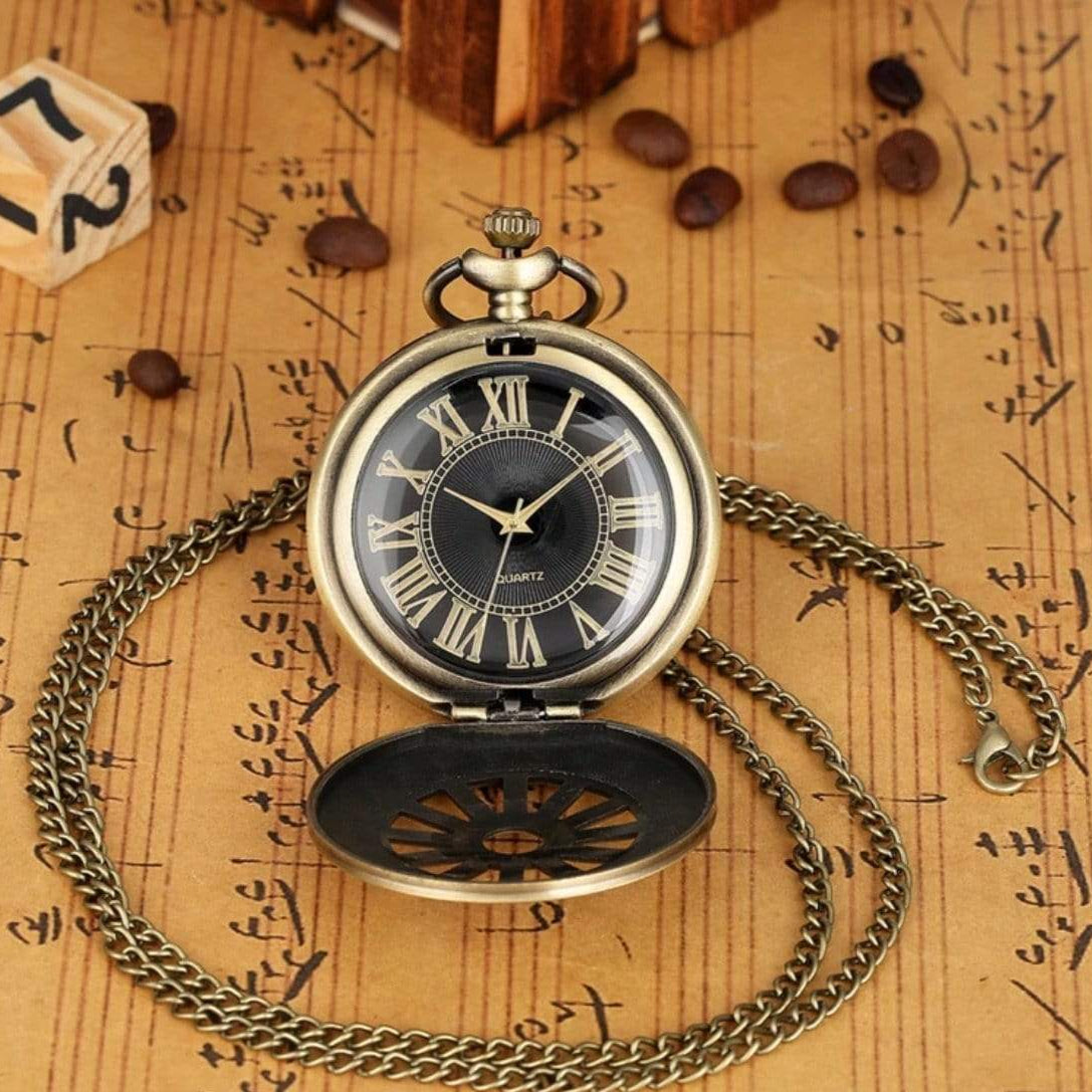 Open bronze pocket watch with chain on sheet music.
