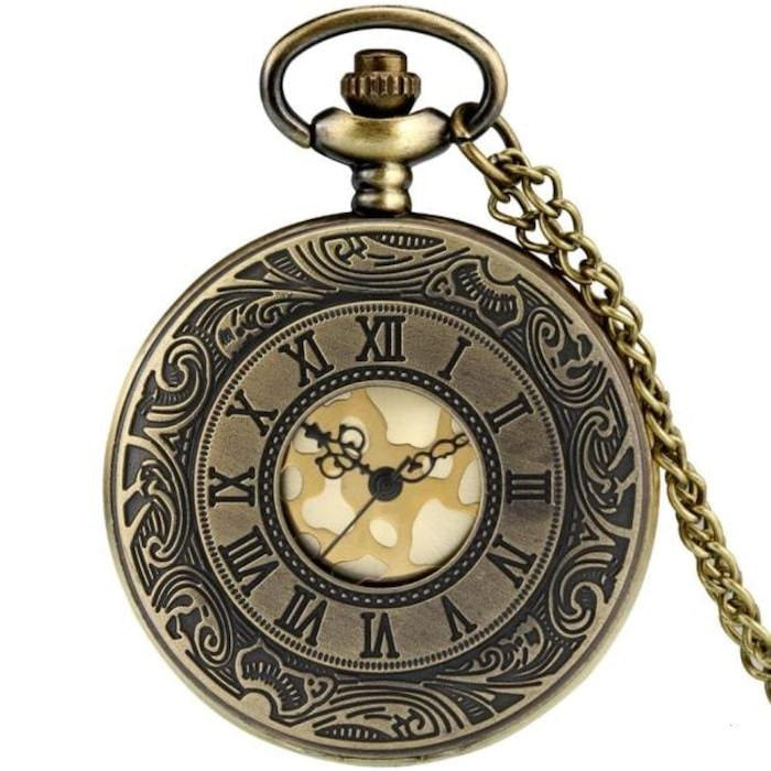 Close-up of an ornate, bronze-colored pocket watch with Roman numerals and a chain.
