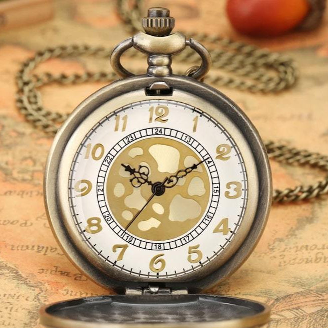 Close-up of an antique bronze pocket watch with an open lid and a chain, set against a vintage map.
