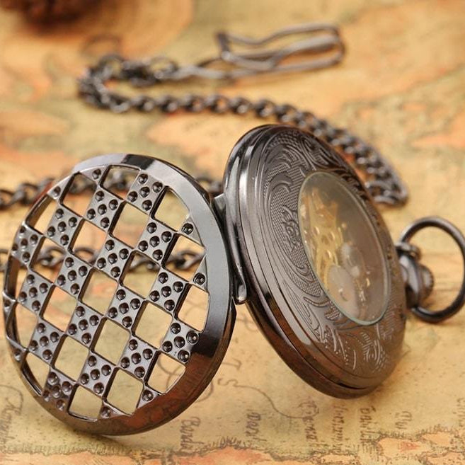 Open antique pocket watch with a patterned case and chain.
