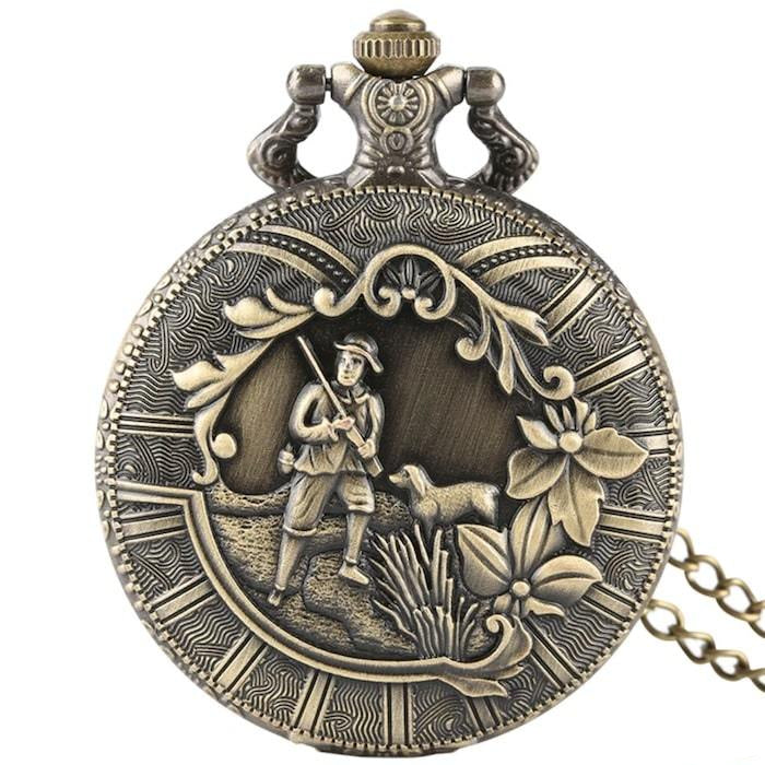 Antique brass pocket watch with a hunting scene.
