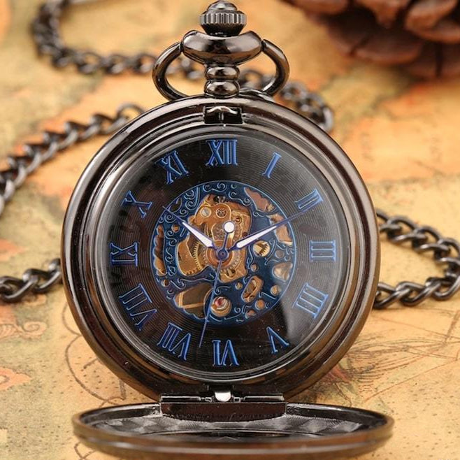 Black pocket watch with blue Roman numerals on a map.
