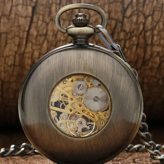 Close-up of a bronze mechanical pocket watch with visible gears.
