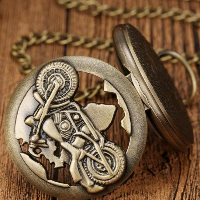 Bronze pocket watch with motorcycle design and chain.
