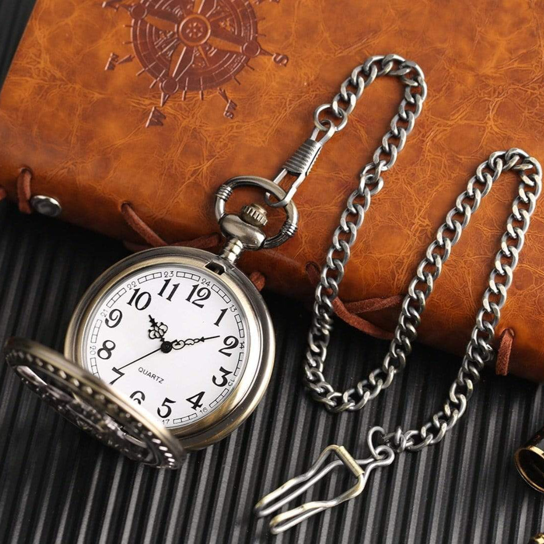 Pocket watch with chain on leather notebook.