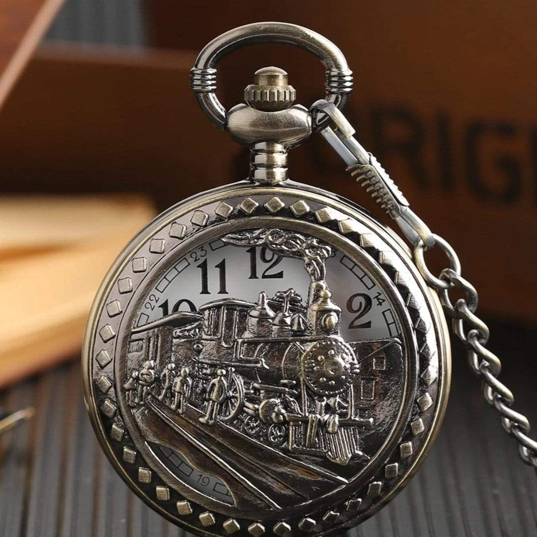 Close-up of a bronze-colored pocket watch with a steam train illustration.
