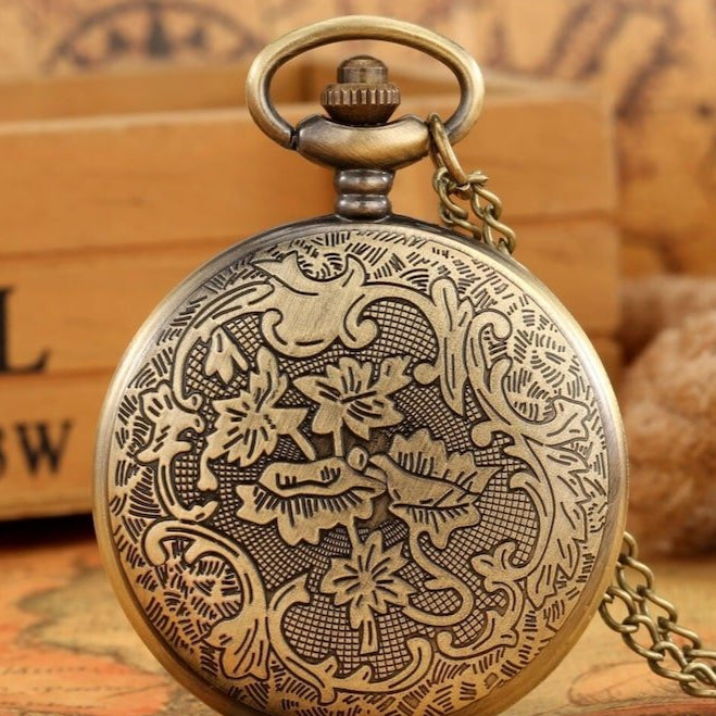 Close-up of a brass pocket watch with floral engravings.