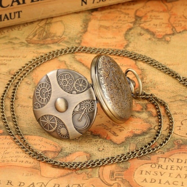 Close-up of bronze-colored steampunk pocket watch with chain atop antique map.