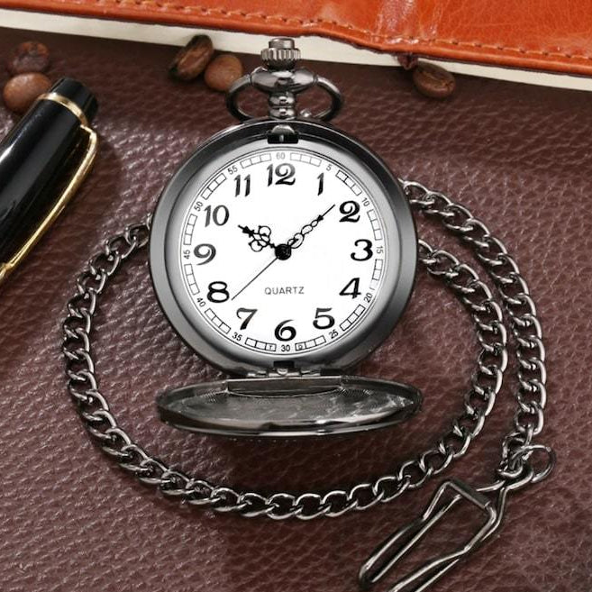 A pocket watch on a brown surface.