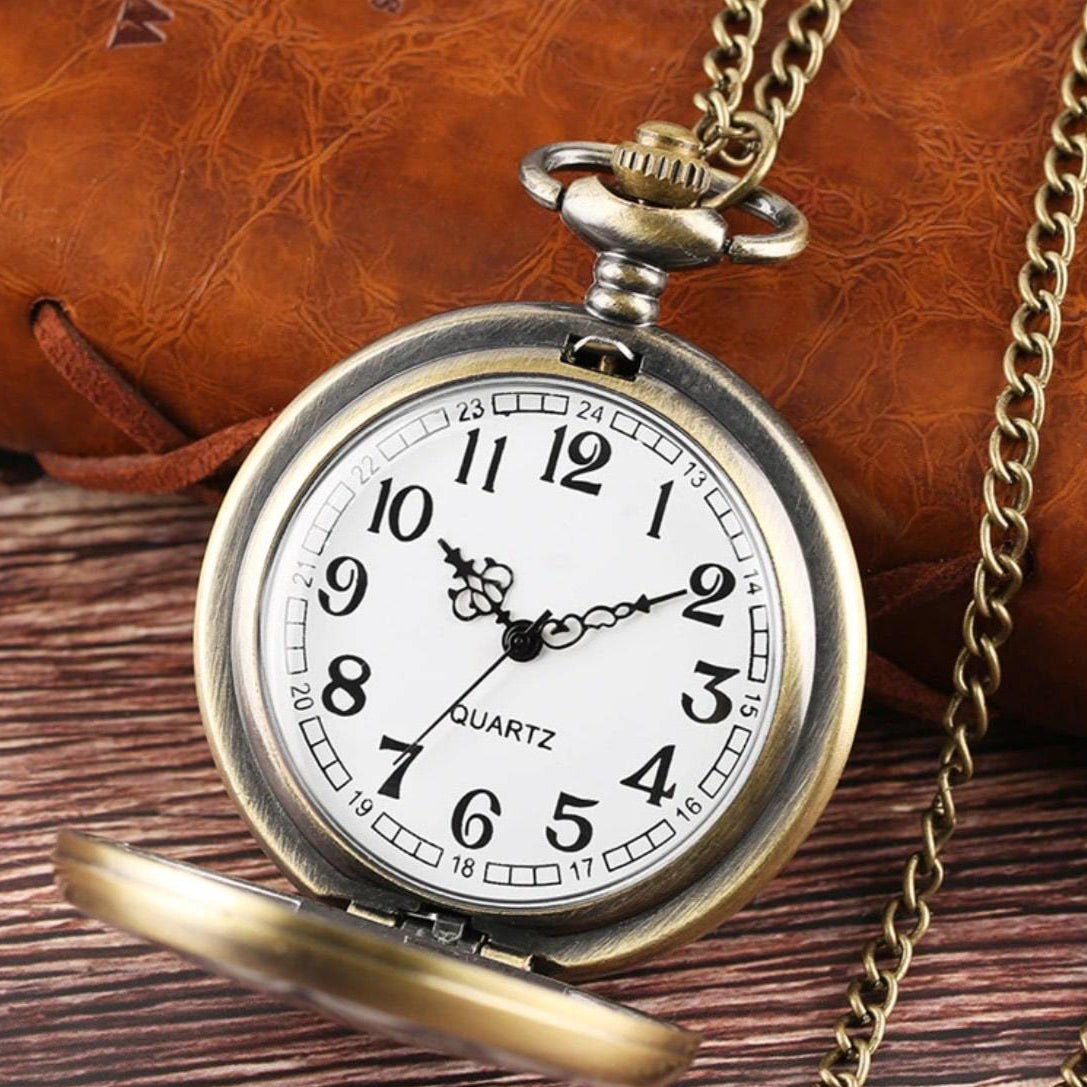 Close-up of an open, antique bronze pocket watch with a chain.
