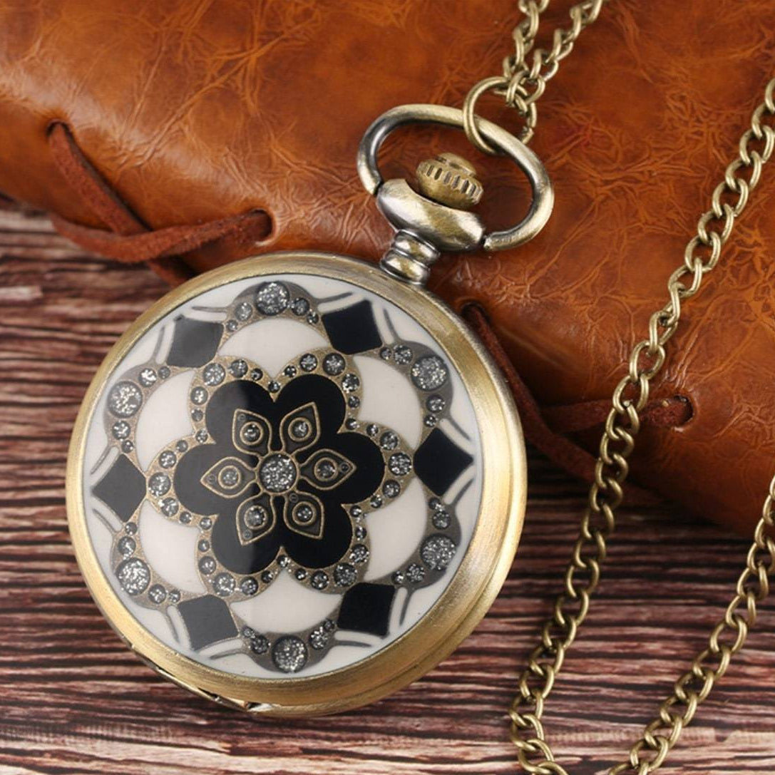 Vintage gold pocket watch with chain, floral design, and jewel accents.