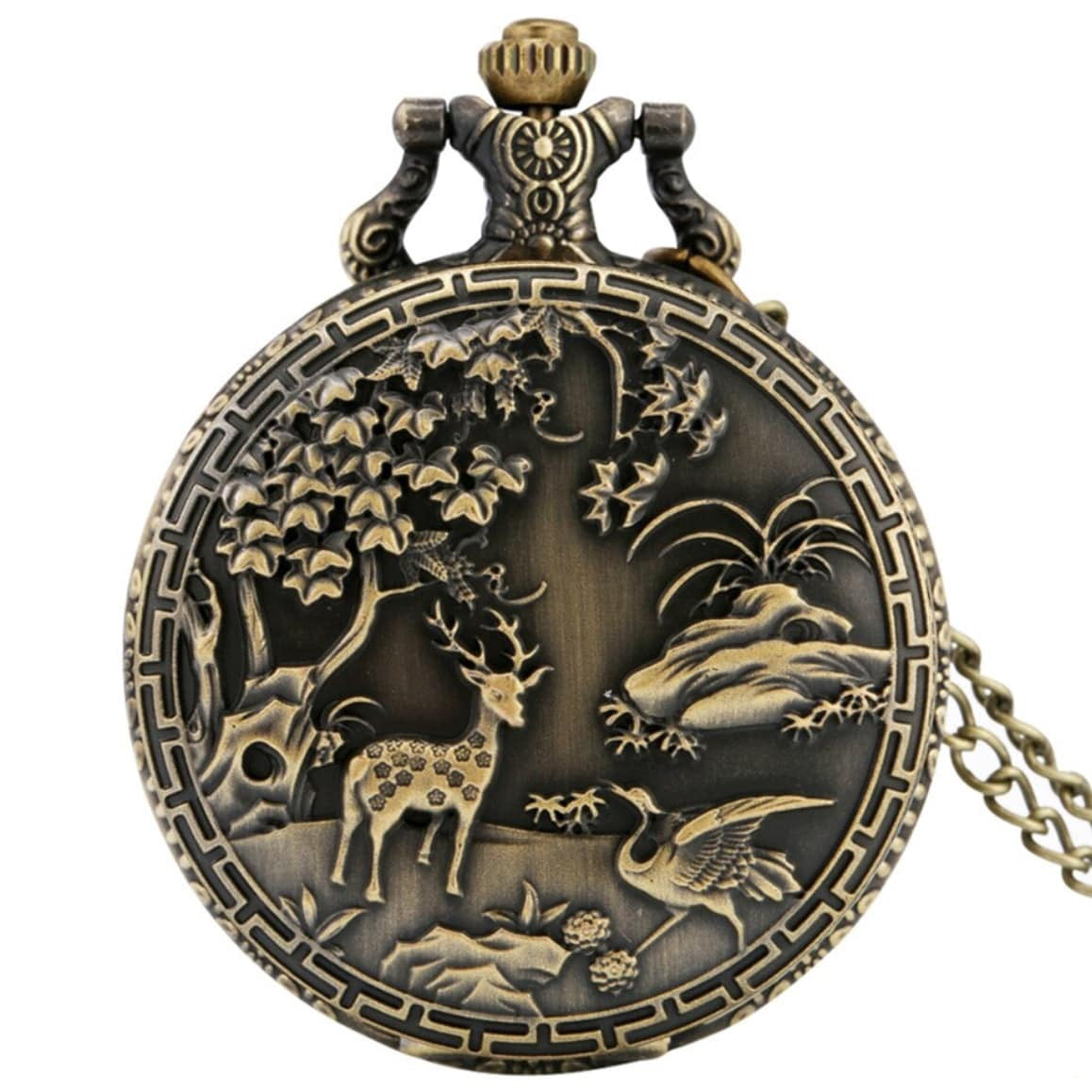 Antique bronze pocket watch featuring a nature scene with a deer, crane, tree, and rocks.
