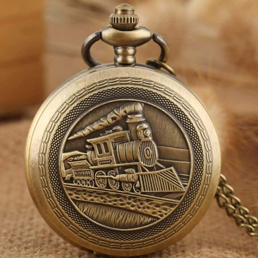 Close-up of a bronze pocket watch with a train design.
