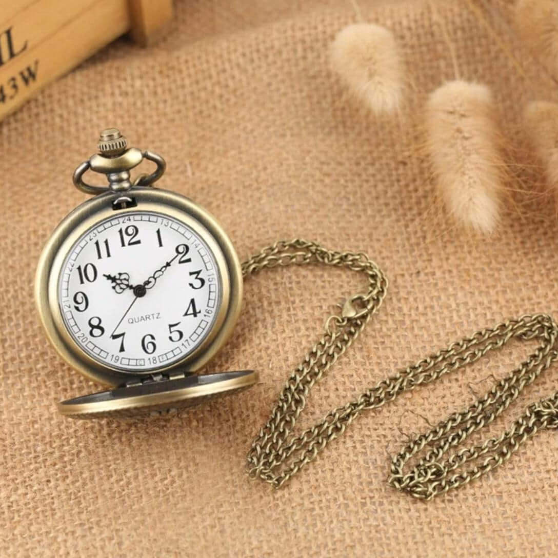 Close-up of a bronze pocket watch with a chain on burlap.