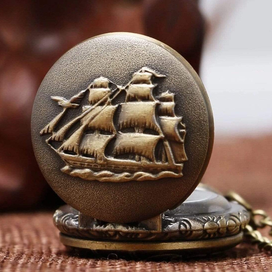 Bronze pocket watch with ship engraving on lid.

