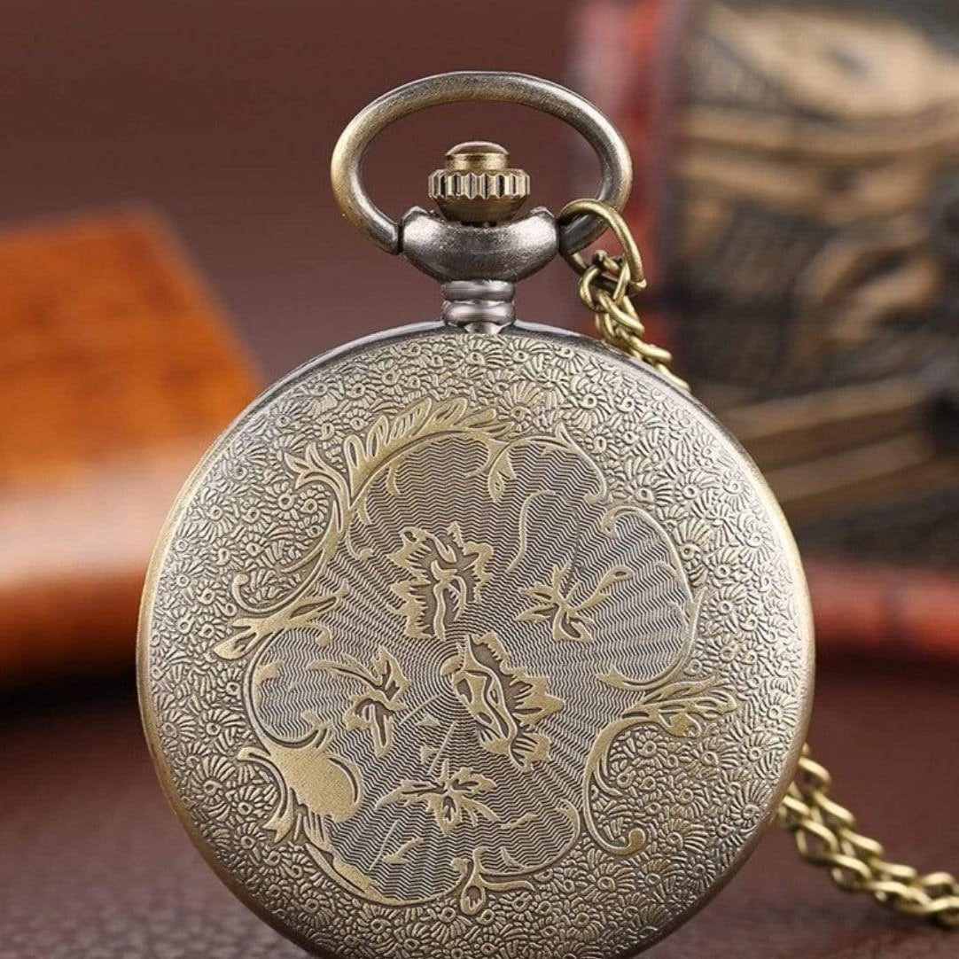 Close-up of an ornate antique pocket watch with a floral design.