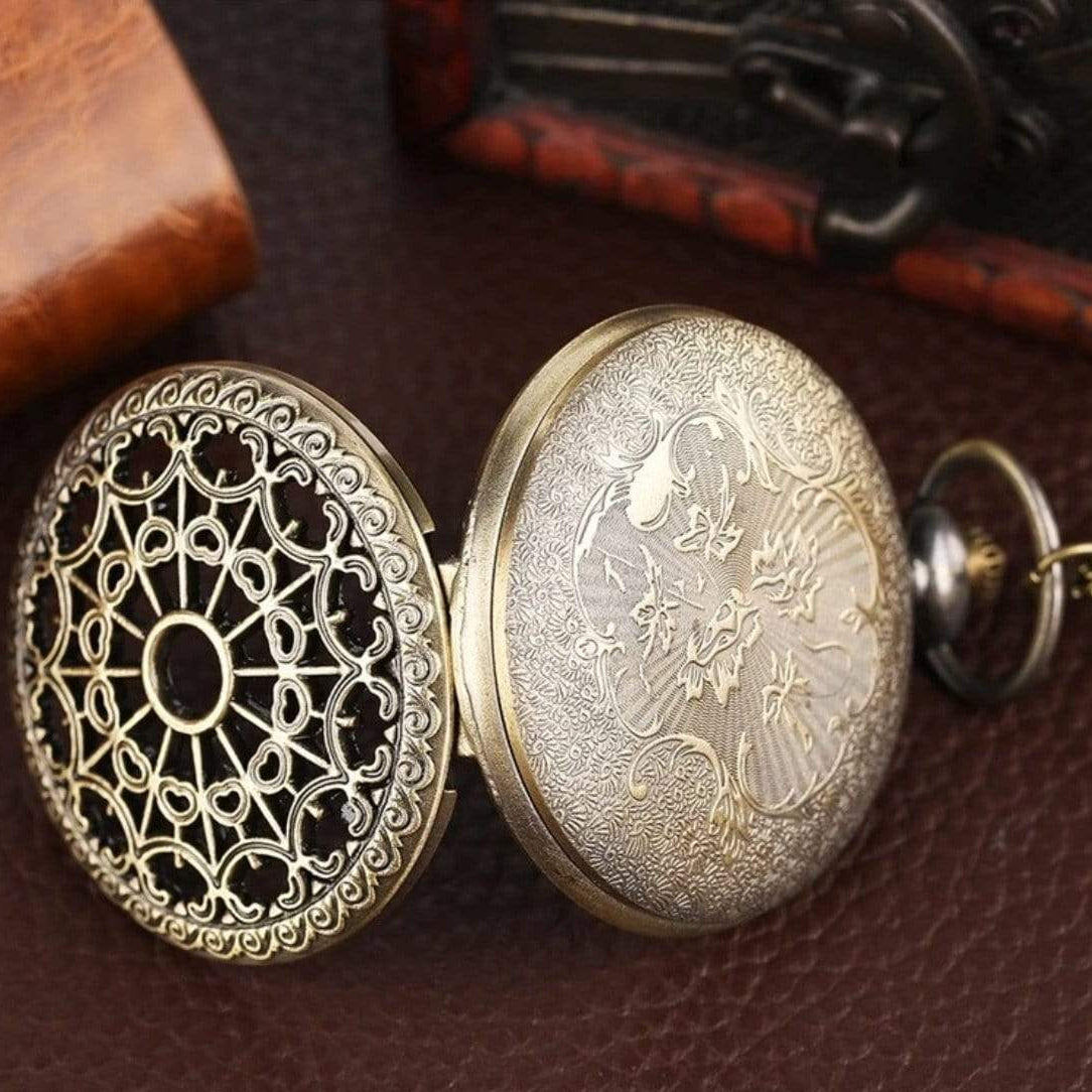 Open antique pocket watch with ornate filigree lid.
