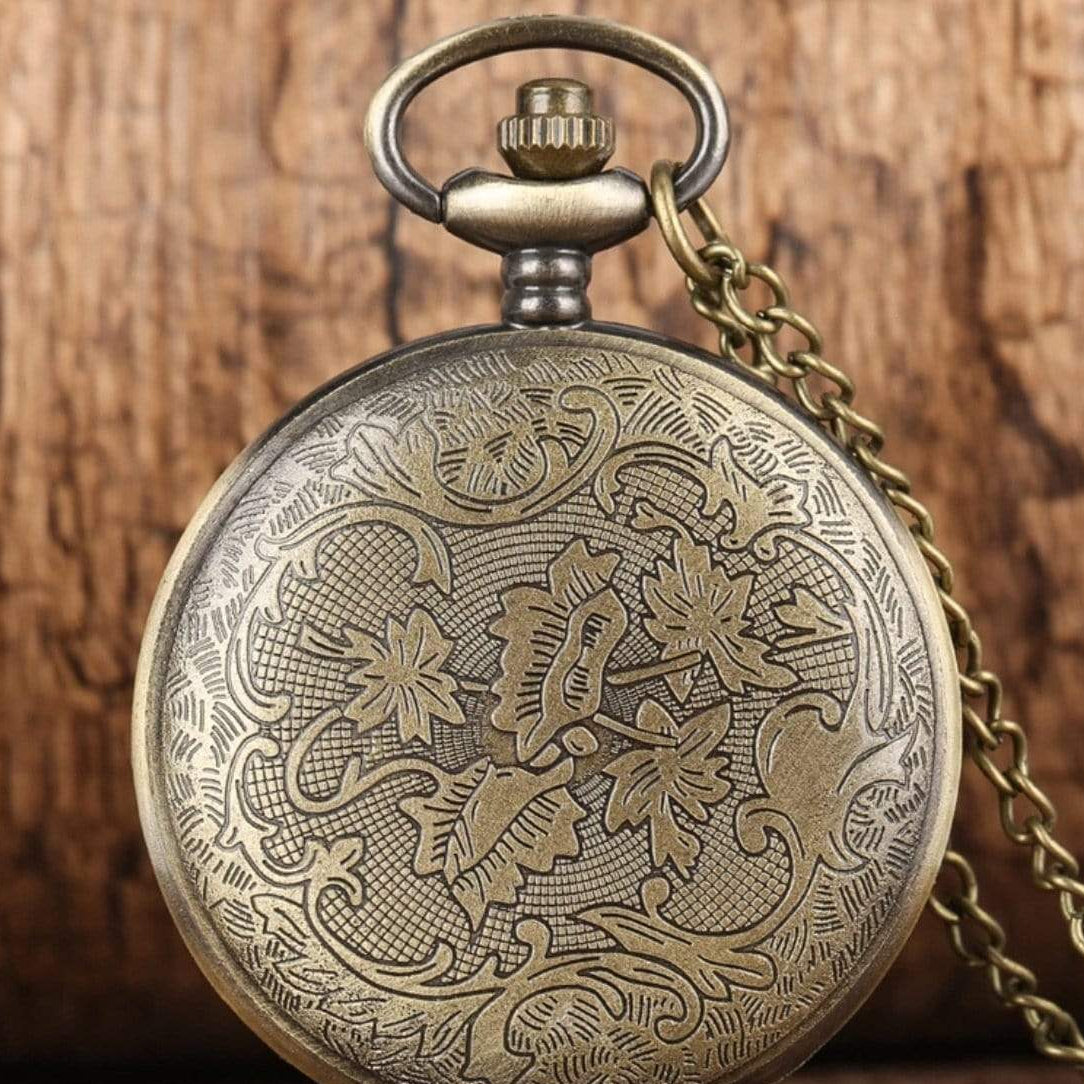 Antique bronze pocket watch with floral detailing and chain.
