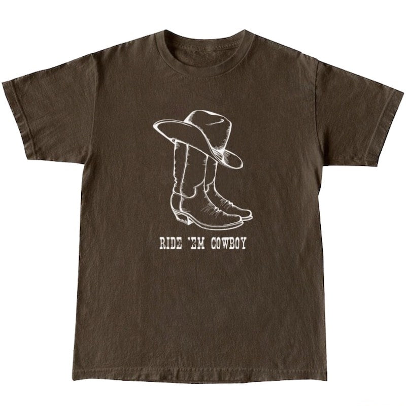 Brown t-shirt with a graphic of a cowboy hat and boots, with the phrase "Ride 'Em Cowboy".
