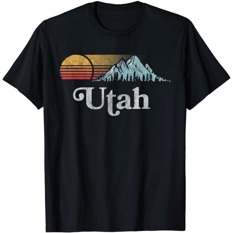 Black t-shirt with retro-style graphic featuring a sunset, mountains, and the word "Utah".
