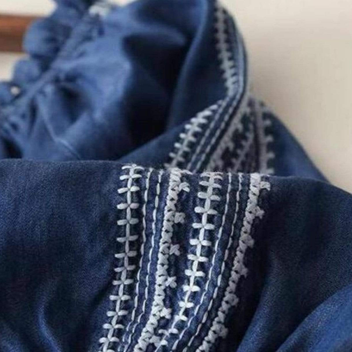 Denim shirt with white embroidery.
